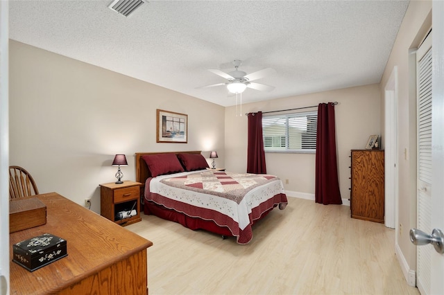 9290 SW 89th Ter Unit D, Ocala, FL 34481 - bedroom with light wood-type flooring, a textured ceiling, baseboards, a ceiling fan, and a closet