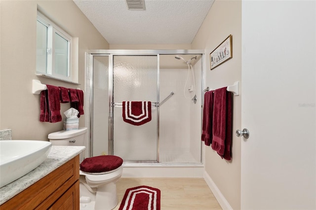 9290 SW 89th Ter Unit D, Ocala, FL 34481 - full bathroom with toilet, a stall shower, a textured ceiling, vanity, and wood finished floors