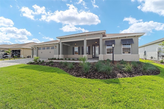 8465 SW 101st Ave, Ocala, FL 34481 - view of front of home with stucco siding, an attached garage, a front yard, and driveway