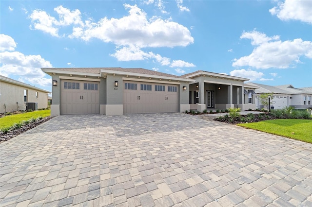 8465 SW 101st Ave, Ocala, FL 34481 - view of front of home with stucco siding, central AC unit, decorative driveway, and an attached garage