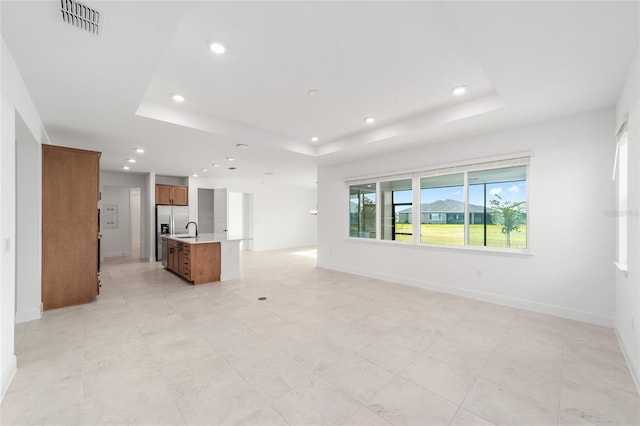 8465 SW 101st Ave, Ocala, FL 34481 - unfurnished living room featuring a raised ceiling, recessed lighting, a sink, and baseboards