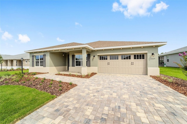 10625 SW 98th Pl, Ocala, FL 34481 - ranch-style house with decorative driveway, an attached garage, stucco siding, and a front yard