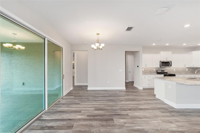 10625 SW 98th Pl, Ocala, FL 34481 - kitchen with stainless steel appliances, a chandelier, light wood-style flooring, baseboards, and recessed lighting