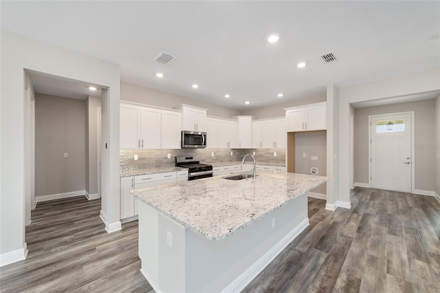 10625 SW 98th Pl, Ocala, FL 34481 - kitchen featuring appliances with stainless steel finishes, a sink, backsplash, dark wood-style flooring, and white cabinetry