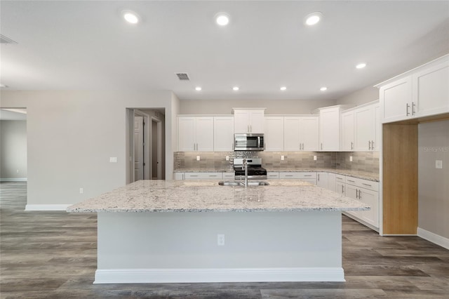 10625 SW 98th Pl, Ocala, FL 34481 - kitchen with appliances with stainless steel finishes, baseboards, a center island with sink, a sink, and backsplash