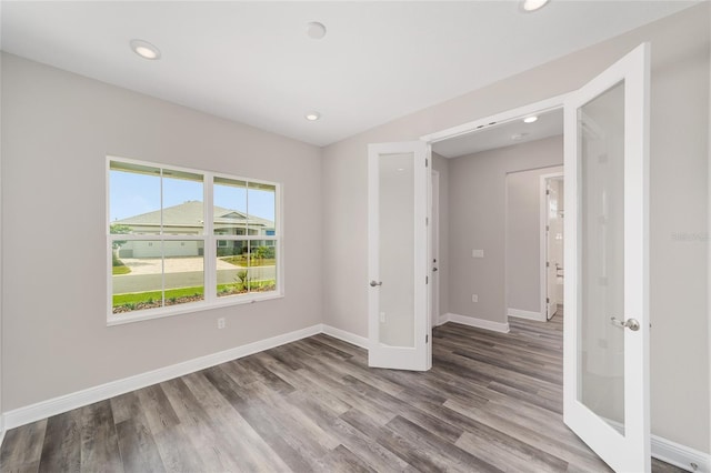 10625 SW 98th Pl, Ocala, FL 34481 - spare room featuring wood finished floors, baseboards, recessed lighting, and french doors