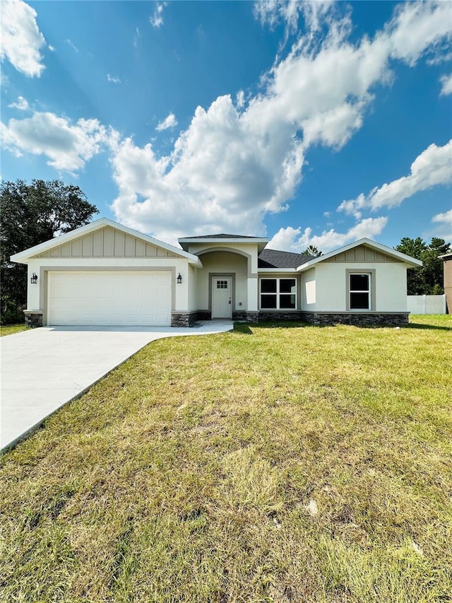 12282 SW 80th St, Dunnellon, FL 34432 - ranch-style home featuring a garage, concrete driveway, board and batten siding, a front yard, and stone siding