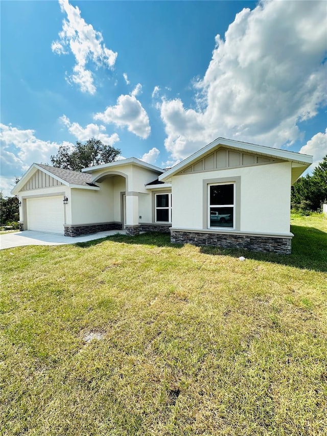 12282 SW 80th St, Dunnellon, FL 34432 - view of front of property featuring an attached garage, stucco siding, a front lawn, and driveway