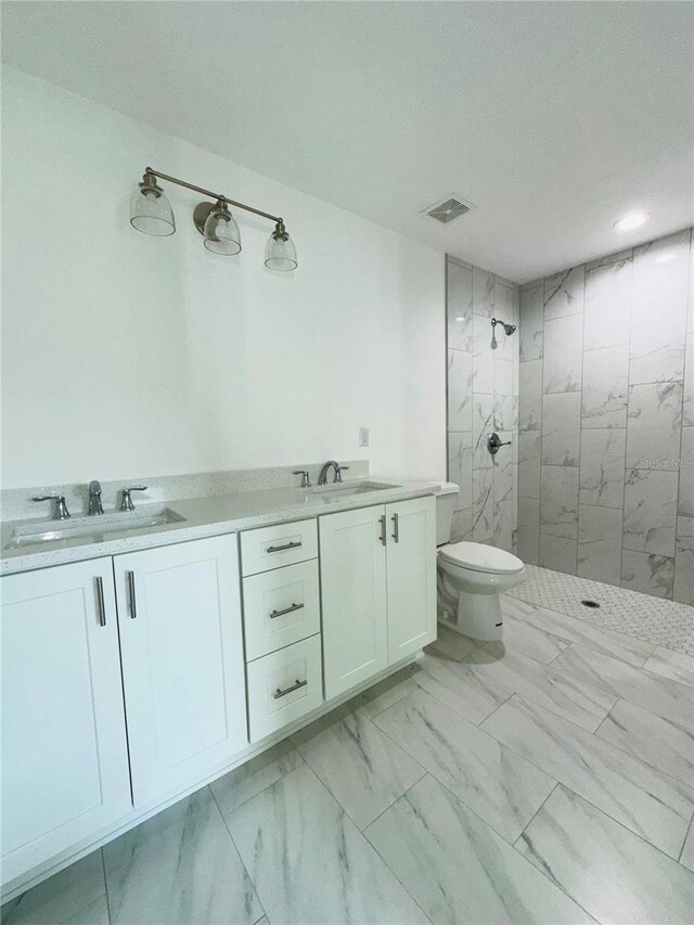 12282 SW 80th St, Dunnellon, FL 34432 - full bath with marble look tile flooring, tiled shower, double vanity, and toilet