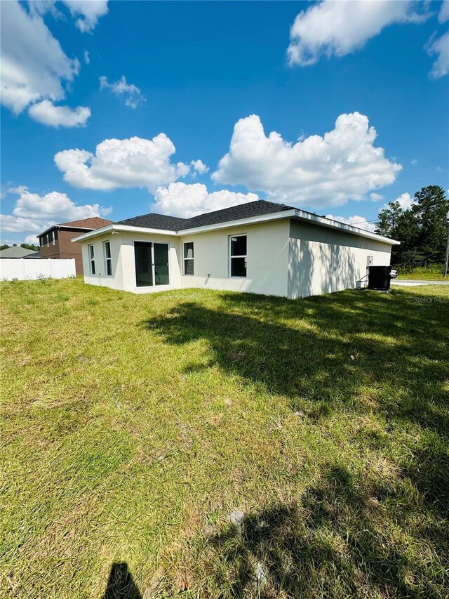 12282 SW 80th St, Dunnellon, FL 34432 - rear view of house with stucco siding and a lawn