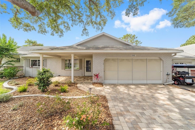 8998 SW 94th St Unit D, Ocala, FL 34481 - ranch-style home with brick siding, a garage, decorative driveway, and covered porch