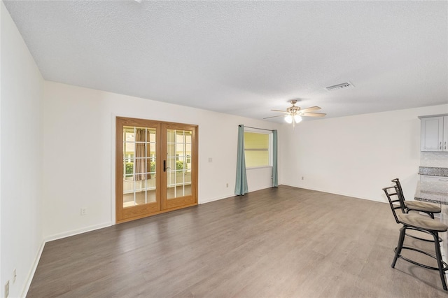 8998 SW 94th St Unit D, Ocala, FL 34481 - unfurnished living room featuring french doors, wood finished floors, ceiling fan, a textured ceiling, and baseboards