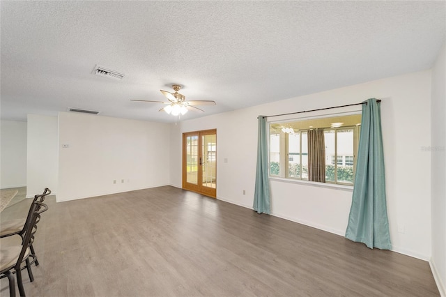 8998 SW 94th St Unit D, Ocala, FL 34481 - empty room with wood finished floors, french doors, a textured ceiling, a ceiling fan, and baseboards