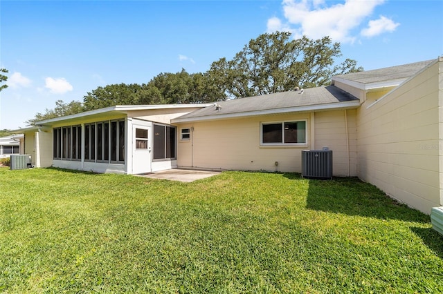 8998 SW 94th St Unit D, Ocala, FL 34481 - back of property with central AC unit, a sunroom, and a lawn