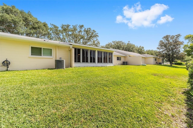 8998 SW 94th St Unit D, Ocala, FL 34481 - rear view of property with a yard, central AC unit, concrete block siding, and a sunroom