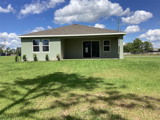 10540 SW 49th Avenue Rd, Ocala, FL 34476 - rear view of property featuring stucco siding, a lawn, and a shingled roof