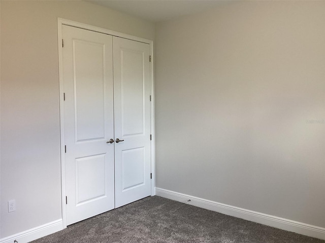 10540 SW 49th Avenue Rd, Ocala, FL 34476 - unfurnished bedroom featuring dark colored carpet, a closet, and baseboards