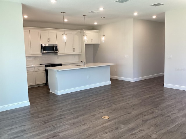 10540 SW 49th Avenue Rd, Ocala, FL 34476 - kitchen with stainless steel microwave, a sink, an island with sink, baseboards, and dark wood-type flooring
