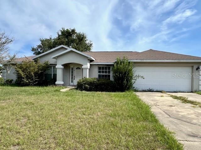 1575 NE 160th Pl, Citra, FL 32113 - ranch-style home featuring driveway, a garage, a front yard, and stucco siding