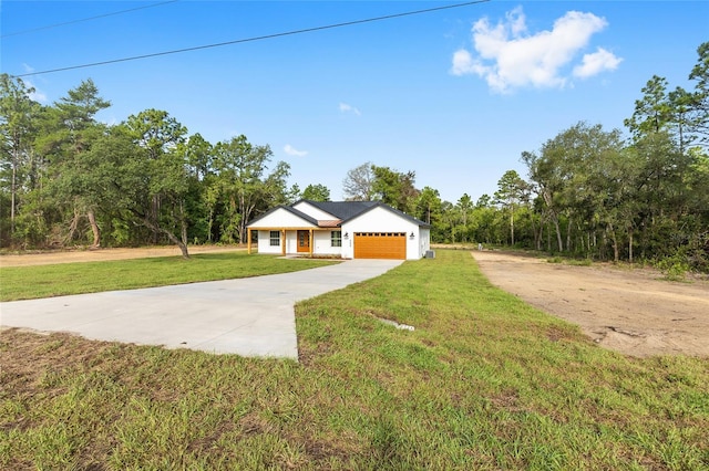 8200 SW 125th Court Rd, Dunnellon, FL 34432 - view of front of home with driveway, a front yard, a garage, and a view of trees