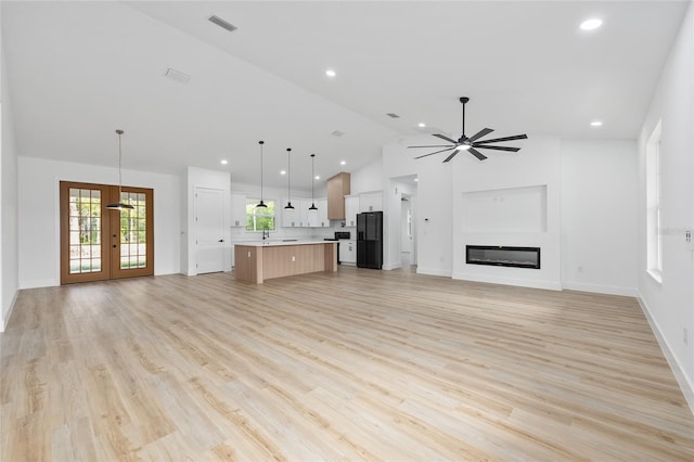 8200 SW 125th Court Rd, Dunnellon, FL 34432 - unfurnished living room with french doors, a ceiling fan, light wood-type flooring, high vaulted ceiling, and recessed lighting