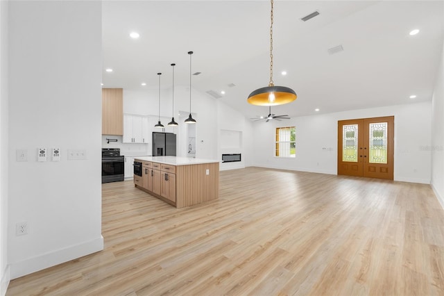 8200 SW 125th Court Rd, Dunnellon, FL 34432 - kitchen with range, stainless steel refrigerator with ice dispenser, light countertops, open floor plan, and decorative light fixtures