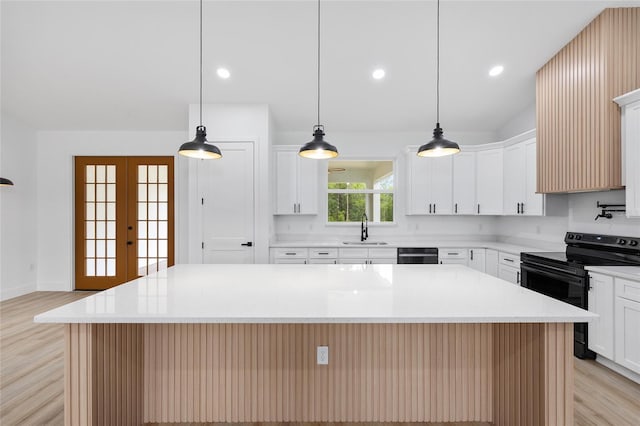 8200 SW 125th Court Rd, Dunnellon, FL 34432 - kitchen with black electric range oven, a sink, light wood finished floors, dishwasher, and a center island