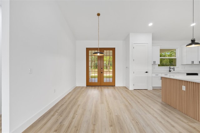 8200 SW 125th Court Rd, Dunnellon, FL 34432 - unfurnished dining area with french doors, light wood-type flooring, a sink, vaulted ceiling, and baseboards
