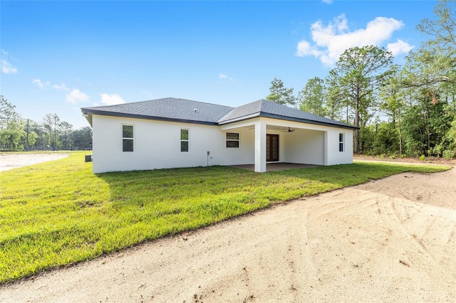8200 SW 125th Court Rd, Dunnellon, FL 34432 - rear view of house featuring ceiling fan, a patio, stucco siding, a yard, and dirt driveway