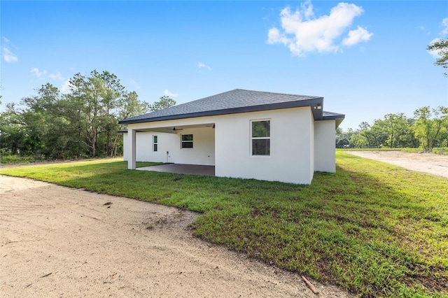 8200 SW 125th Court Rd, Dunnellon, FL 34432 - back of property with stucco siding, a patio, a yard, a ceiling fan, and roof with shingles