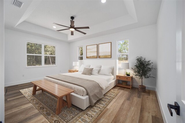 8200 SW 125th Court Rd, Dunnellon, FL 34432 - bedroom featuring a tray ceiling, multiple windows, baseboards, wood finished floors, and recessed lighting