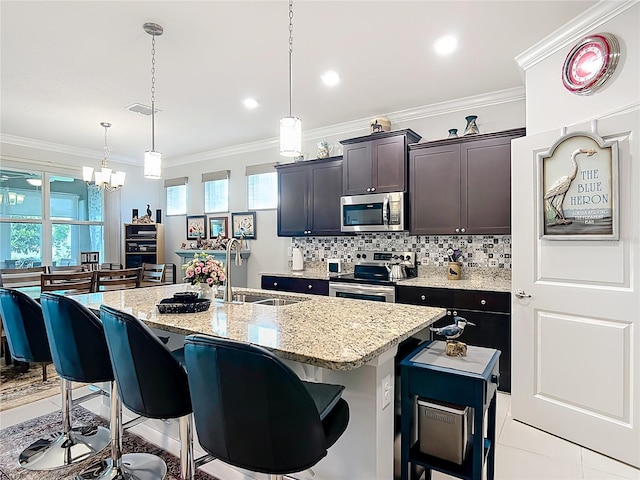 9237 SW 60th Terrace Rd, Ocala, FL 34476 - kitchen featuring appliances with stainless steel finishes, a sink, a kitchen breakfast bar, a chandelier, and plenty of natural light