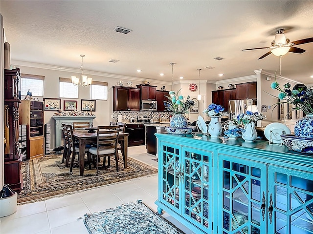 9237 SW 60th Terrace Rd, Ocala, FL 34476 - dining area featuring ceiling fan, a chandelier, light tile patterned flooring, and crown molding