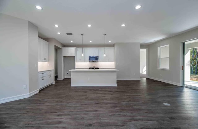 5830 SW 121st Ter, Ocala, FL 34481 - kitchen featuring stainless steel microwave, white cabinets, baseboards, a center island with sink, and recessed lighting