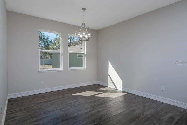 5830 SW 121st Ter, Ocala, FL 34481 - spare room featuring baseboards, dark wood-style flooring, and a chandelier