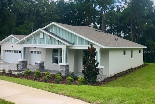 5830 SW 121st Ter, Ocala, FL 34481 - craftsman-style home featuring a front lawn, an attached garage, stucco siding, and covered porch