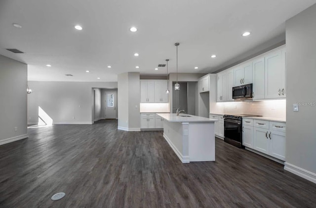 5830 SW 121st Ter, Ocala, FL 34481 - kitchen with stainless steel microwave, black range with electric stovetop, open floor plan, dark wood finished floors, and white cabinets