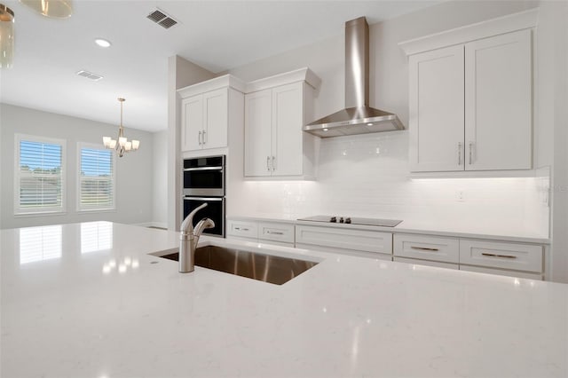 2050 NW 79th Loop, Ocala, FL 34475 - kitchen with wall chimney range hood, double wall oven, a sink, decorative backsplash, and white cabinetry
