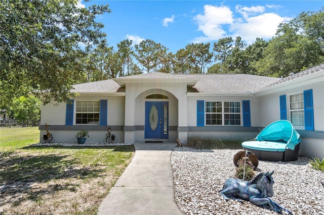 2698 SW 186th Ct, Dunnellon, FL 34432 - ranch-style home with stucco siding, roof with shingles, and a front lawn
