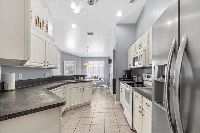 2698 SW 186th Ct, Dunnellon, FL 34432 - kitchen with white appliances, dark countertops, a peninsula, light tile patterned floors, and pendant lighting
