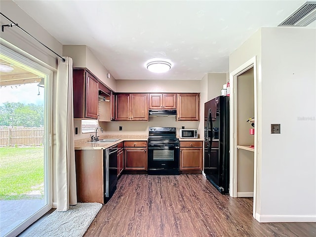 1520 NE 17th Ave, Ocala, FL 34470 - kitchen featuring black appliances, a sink, dark wood-style flooring, light countertops, and under cabinet range hood