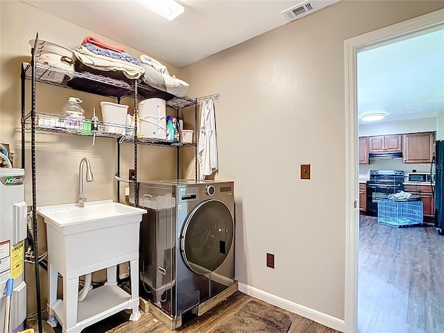 1520 NE 17th Ave, Ocala, FL 34470 - laundry area featuring wood finished floors, water heater, washer / clothes dryer, and baseboards