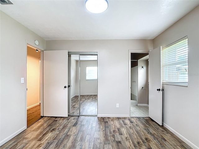 1520 NE 17th Ave, Ocala, FL 34470 - unfurnished bedroom featuring wood finished floors, a closet, baseboards, and ensuite bath