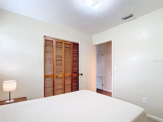 1520 NE 17th Ave, Ocala, FL 34470 - bedroom with a closet, a textured ceiling, and baseboards