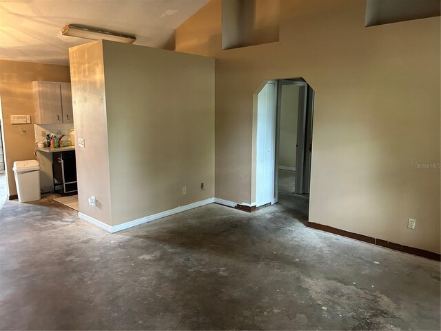 3885 NE 28th Ter, Ocala, FL 34479 - empty room featuring concrete floors, arched walkways, and baseboards