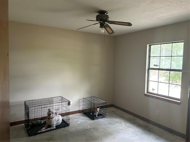 3885 NE 28th Ter, Ocala, FL 34479 - spare room featuring unfinished concrete flooring, baseboards, and a ceiling fan