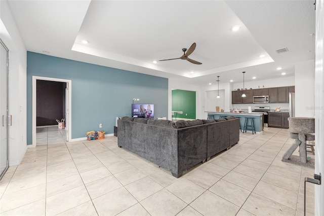 6486 SW 75th Avenue Rd, Ocala, FL 34474 - living room with a raised ceiling, recessed lighting, ceiling fan, light tile patterned floors, and baseboards