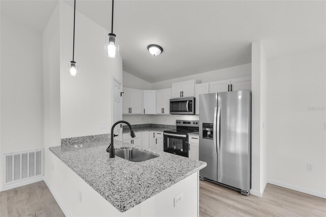 5709 NW 6th Pl, Ocala, FL 34482 - kitchen with stainless steel appliances, a sink, a peninsula, white cabinets, and light wood-type flooring