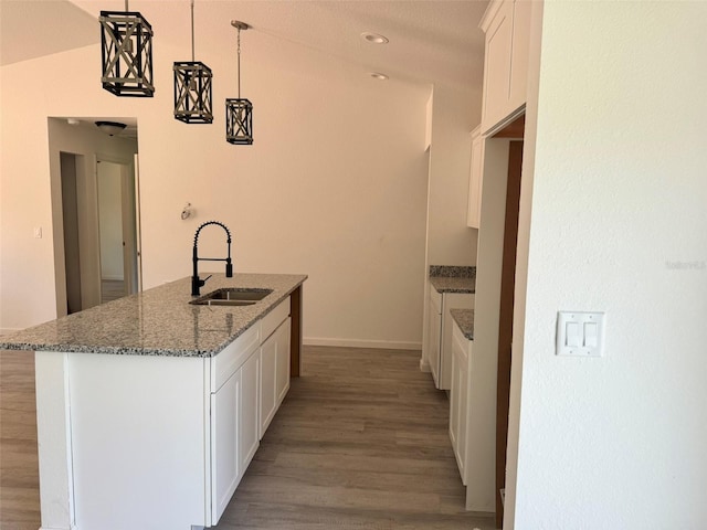5709 NW 6th Pl, Ocala, FL 34482 - kitchen with light wood-style flooring, white cabinets, dark stone counters, an island with sink, and pendant lighting