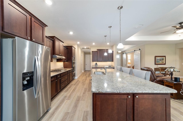 9607 SW 79th Lane Rd, Ocala, FL 34481 - kitchen featuring appliances with stainless steel finishes, a barn door, open floor plan, under cabinet range hood, and a sink